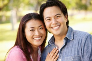 Asian couple head and shoulders portrait outdoors
